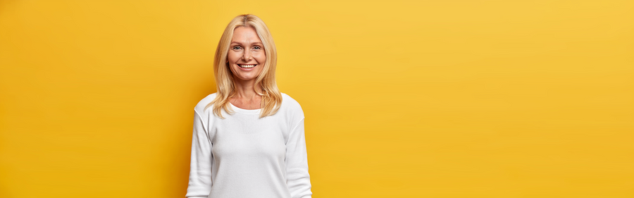 A blond, middle-aged woman smiling in a white background